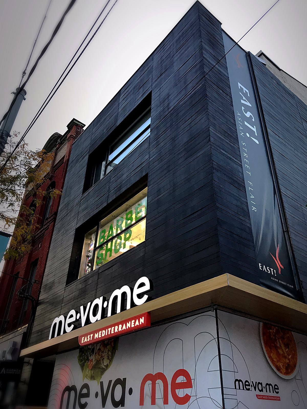 Modern black commercial restaurant facade with illuminated signage